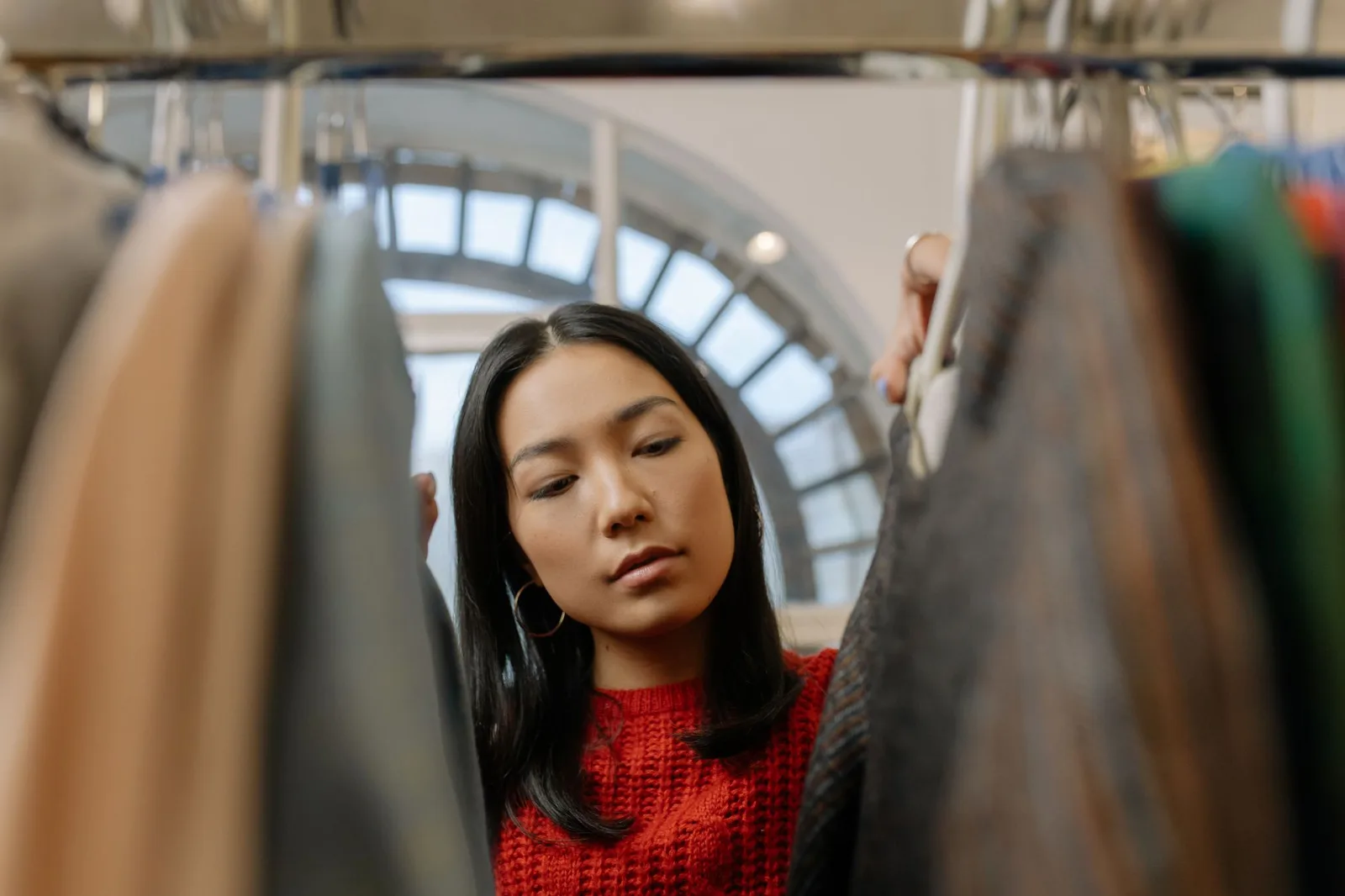 Portant de vêtements classés par couleur sur un marché